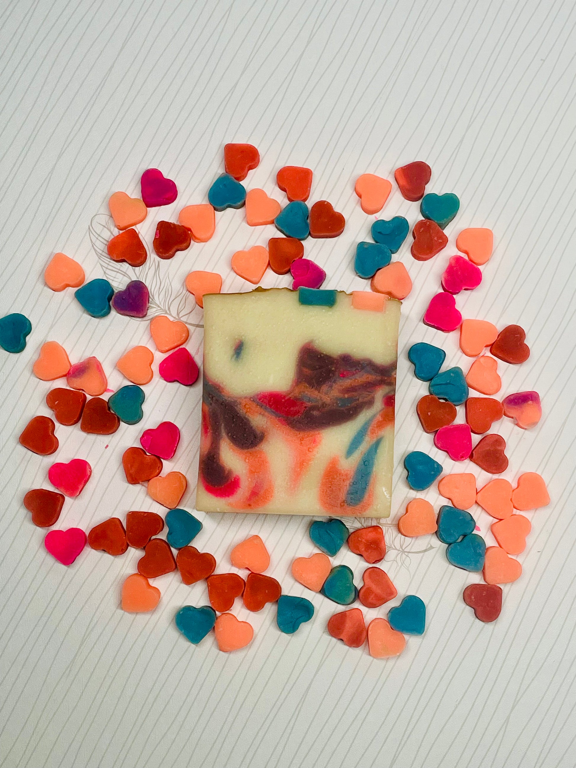 Mini colorful hearts surrounding one soap bar with colorful swirls